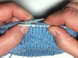 put left needle into back of stitch on right needle and wrap wool from top to bottom